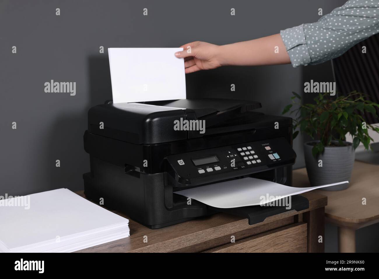 Donna che usa una stampante moderna alla scrivania di legno a casa, primo  piano Foto stock - Alamy