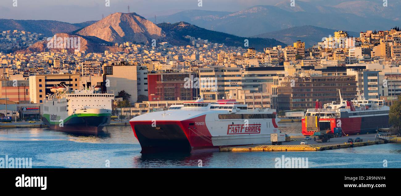 Il Pireo è una trafficata città portuale mediterranea all'interno dell'area urbana di Atene, nella regione dell'Attica in Grecia. Qui lo vediamo al tramonto, visto dal nostro cr Foto Stock