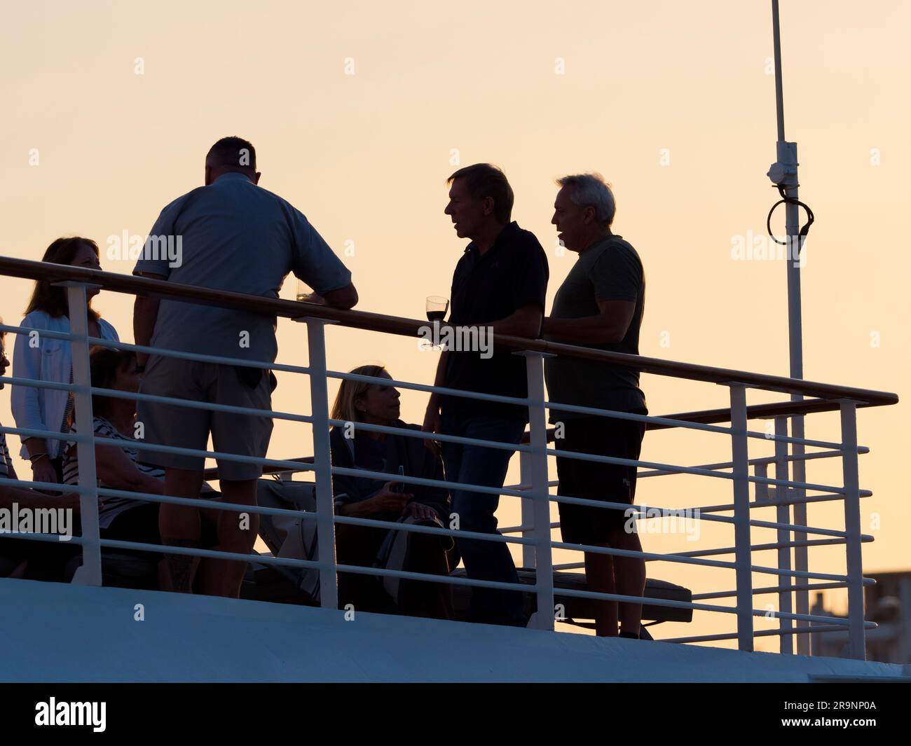 Il Pireo è una trafficata città portuale mediterranea all'interno dell'area urbana di Atene, nella regione dell'Attica in Grecia. Qui vediamo un gruppo di turisti che chiacchierano e.. Foto Stock