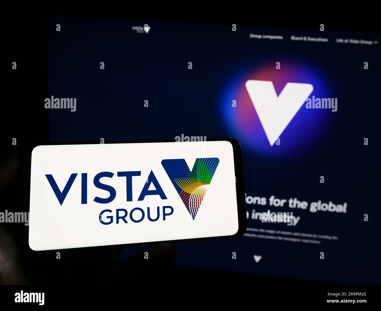 Persona che possiede uno smartphone con il logo della società Vista Group International Limited sullo schermo di fronte al sito Web. Concentrarsi sul display del telefono. Foto Stock