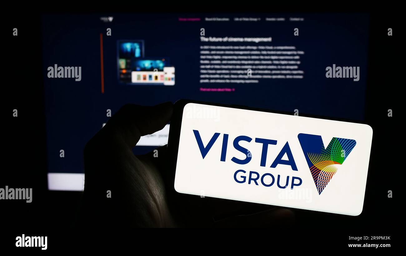 Persona che possiede il cellulare con il logo della società Vista Group International Limited sullo schermo davanti alla pagina Web aziendale. Concentrarsi sul display del telefono. Foto Stock