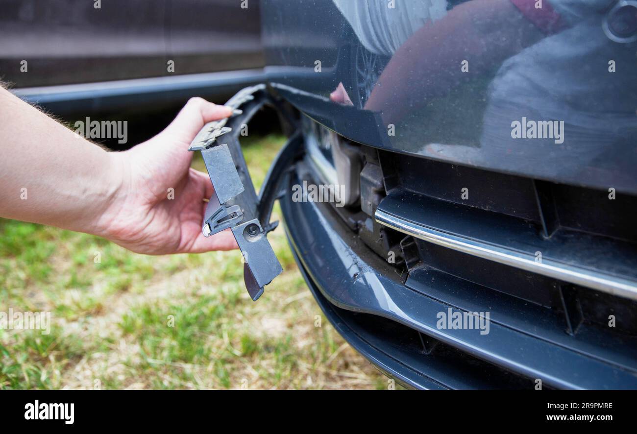 Smontaggio e rimozione del fendinebbia da una vettura per sostituire una lampadina bruciata. Foto Stock