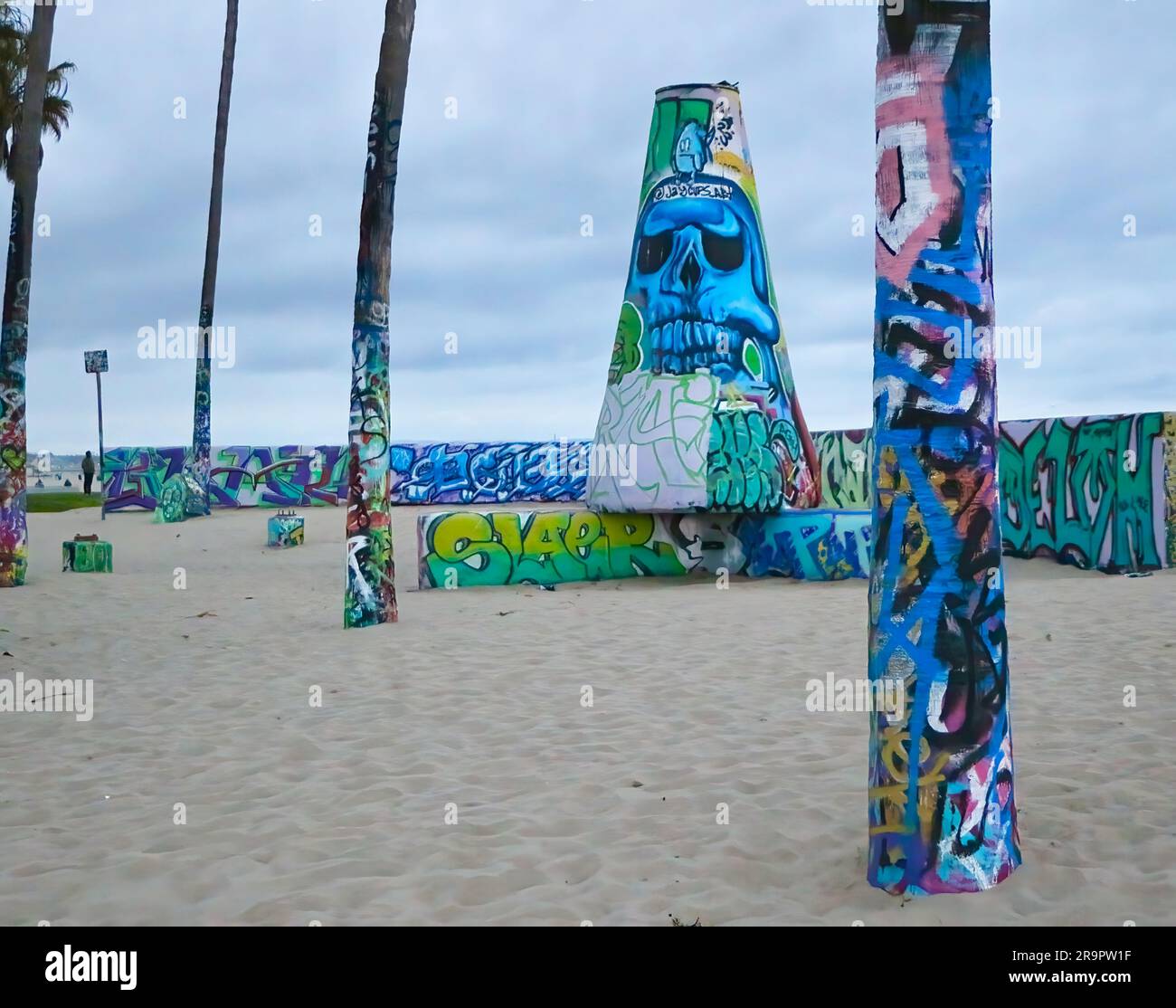 Graffiti dipinti su tronchi di palma e cemento accanto allo skatepark Venice Beach, Santa Monica California USA Foto Stock