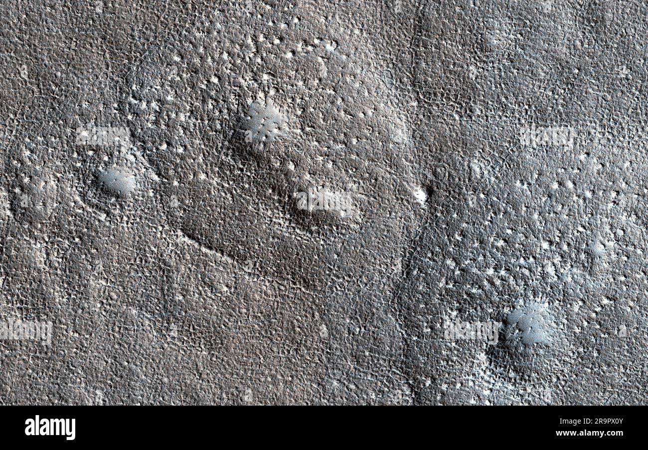 Crateri saltati e ampliati. Si pensa che i crateri espansi su Marte si verifichino quando le pendenze superiori di un cratere da impatto in un sublimato bersaglio ricco di ghiaccio (che va direttamente da uno stato solido a uno gassoso). Il ghiaccio vaporizzante fa ritirarsi le pareti mentre le pendenze inferiori sono corazzate da polvere e detriti, con conseguente formazione a forma di imbuto. I crateri espansi in questa immagine hanno una consistenza insolitamente irregolare nel grembiule esterno dove si è verificata la sublimazione. I dossi sono troppo grandi per essere massi. Ciò suggerisce che il ghiaccio aveva concentrazioni di altro materiale. https //photojournal.jpl.nasa.gov/catalog/PI Foto Stock