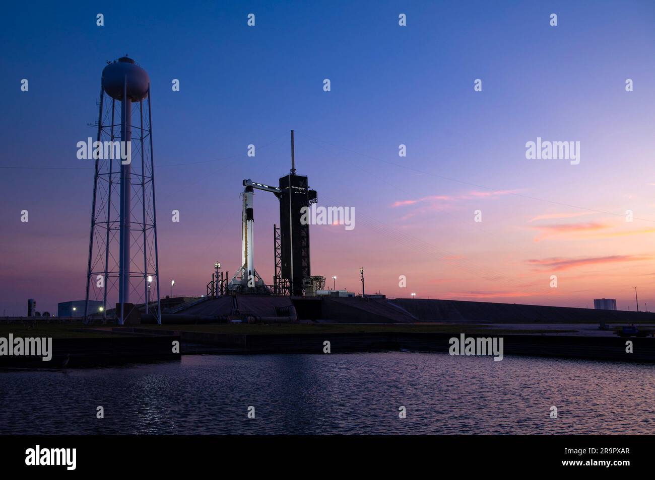 SpaceX Crew-6 Sunset al LC-39A. Un tramonto colorato fa da sfondo al razzo Falcon 9 di SpaceX e alla navicella Dragon Endeavour sul pad al Launch Complex 39A al Kennedy Space Center in Florida il 23 febbraio 2023, per la missione SpaceX Crew-6 della NASA. Il braccio di accesso dell'equipaggio è stato spostato in posizione presso la navicella Dragon. Gli astronauti della NASA Stephen Bowen, comandante di veicoli spaziali, e Warren "Woody" Hoburg, pilota, insieme agli specialisti di missione Sultan Alneyadi, astronauta degli Emirati Arabi Uniti, e Andrei Fedyaev, cosmonauta di Roscosmos, sono in programma per il lancio alla stazione spaziale Internazionale A. Foto Stock