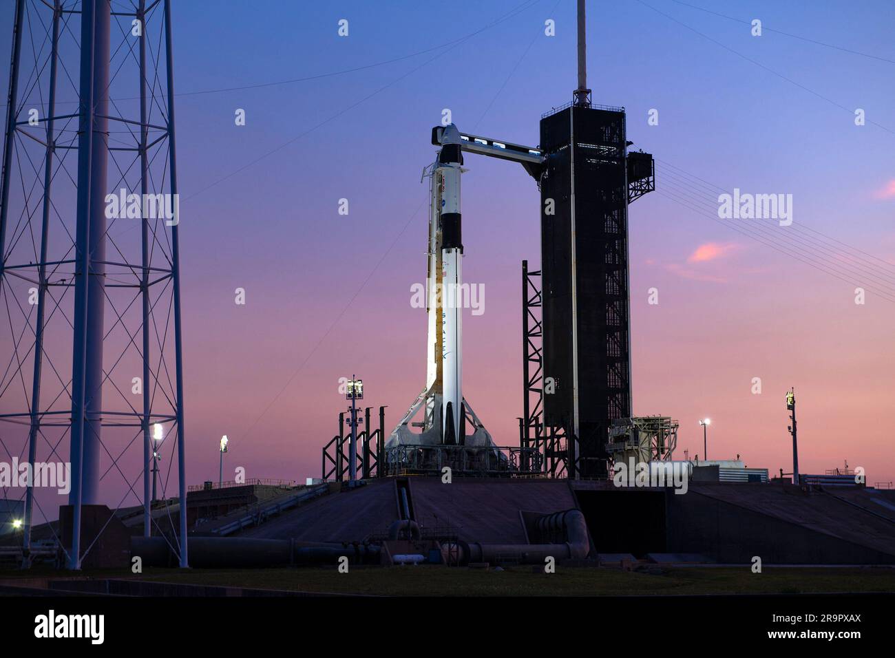 SpaceX Crew-6 Sunset al LC-39A. Un tramonto colorato fa da sfondo al razzo Falcon 9 di SpaceX e alla navicella Dragon Endeavour sul pad al Launch Complex 39A al Kennedy Space Center in Florida il 23 febbraio 2023, per la missione SpaceX Crew-6 della NASA. Il braccio di accesso dell'equipaggio è stato spostato in posizione presso la navicella Dragon. Gli astronauti della NASA Stephen Bowen, comandante di veicoli spaziali, e Warren "Woody" Hoburg, pilota, insieme agli specialisti di missione Sultan Alneyadi, astronauta degli Emirati Arabi Uniti, e Andrei Fedyaev, cosmonauta di Roscosmos, sono in programma per il lancio alla stazione spaziale Internazionale A. Foto Stock