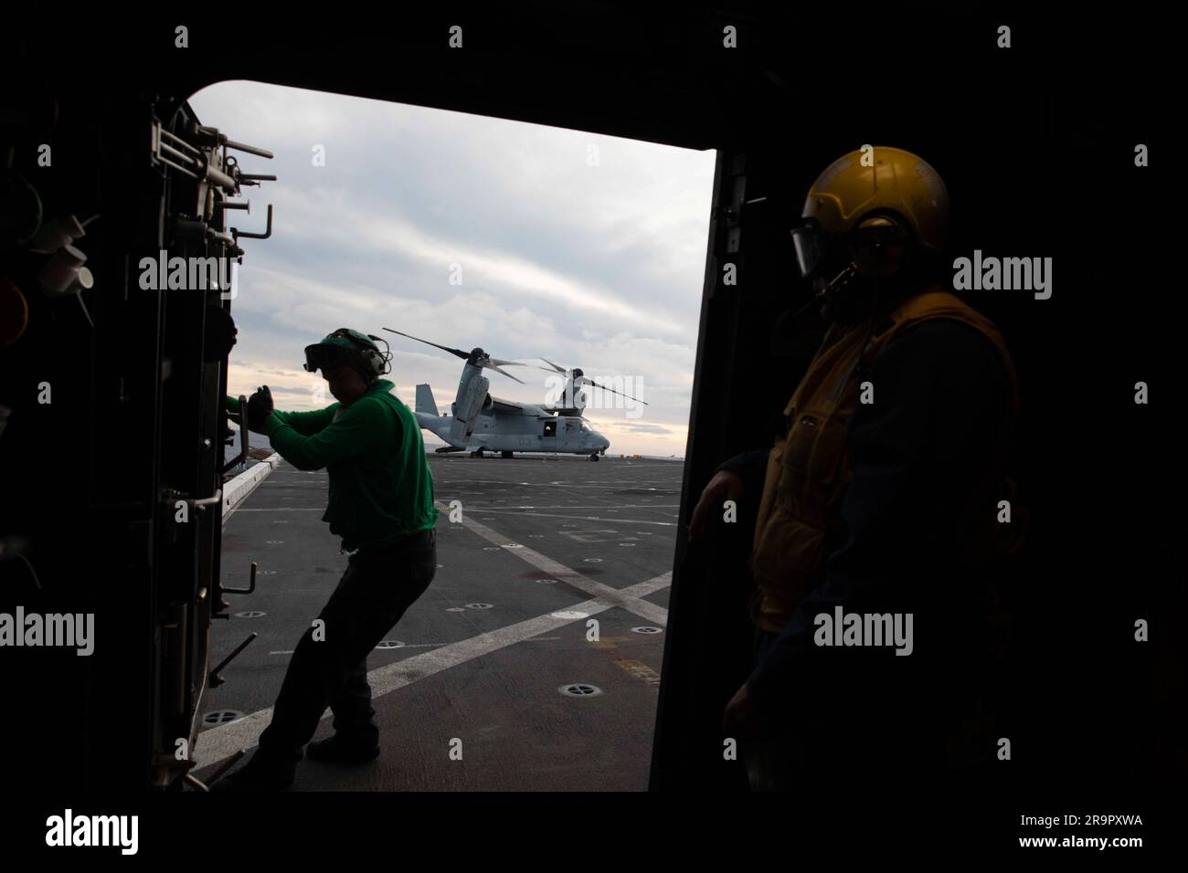 Orion Splash Down e Recovery Operations. Un membro degli Stati Uniti La squadra di elicotteri della Marina a bordo della USS Portland apre una porta al ponte di volo dopo che un V-22 Osprey atterra prima dello splashdown Orion della NASA per la missione Artemis i l'11 dicembre 2022. Foto Stock