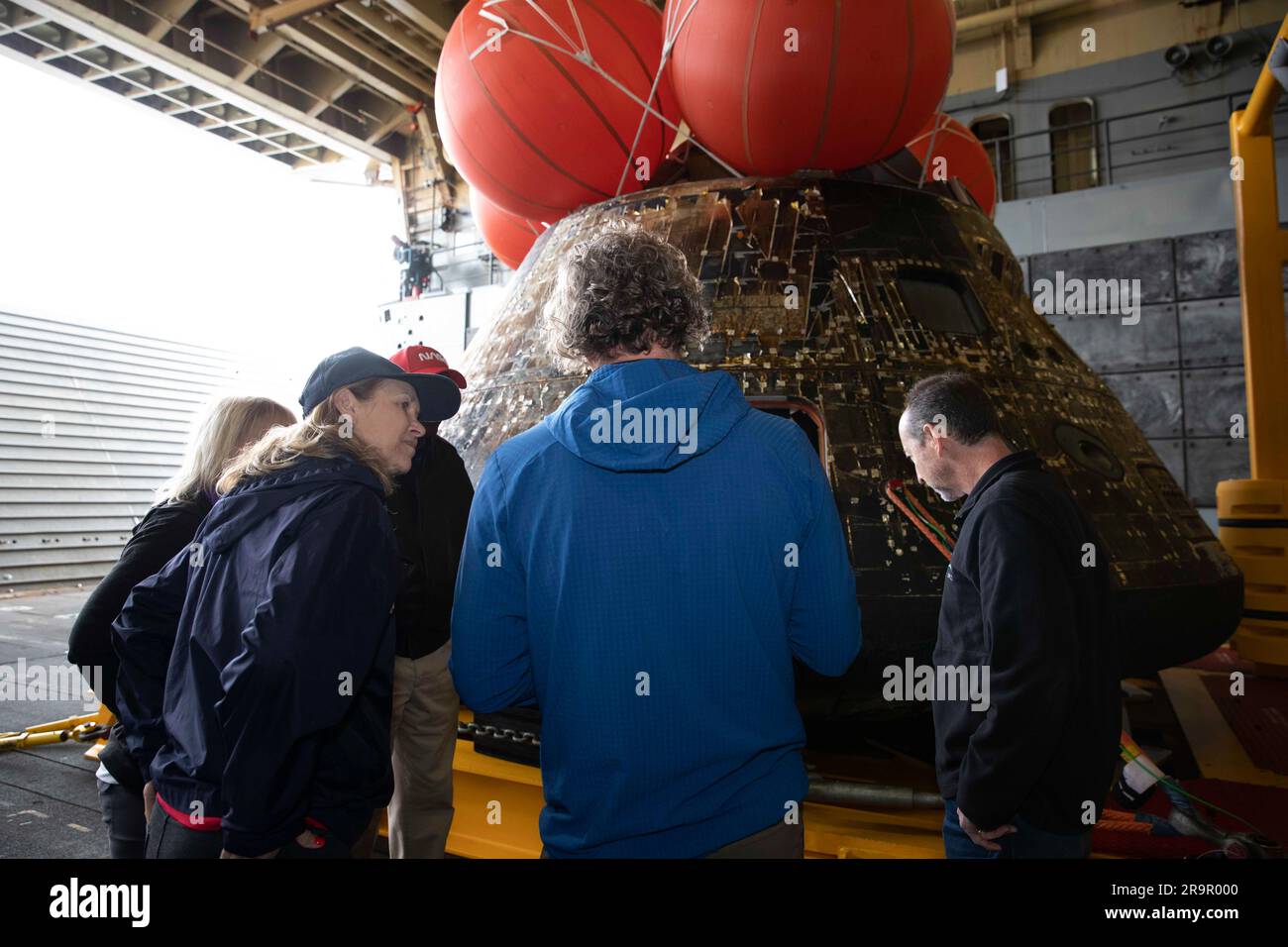 Il direttore del Kennedy Space Center Janet Petro e i membri del team di recupero ispezionano la navicella Artemis i Orion messa in sicurezza all'interno del ponte pozzo della USS Portland dopo il suo atterraggio dell'11 dicembre 2022. I sommozzatori della Marina degli Stati Uniti hanno supportato le operazioni di recupero. Foto Stock