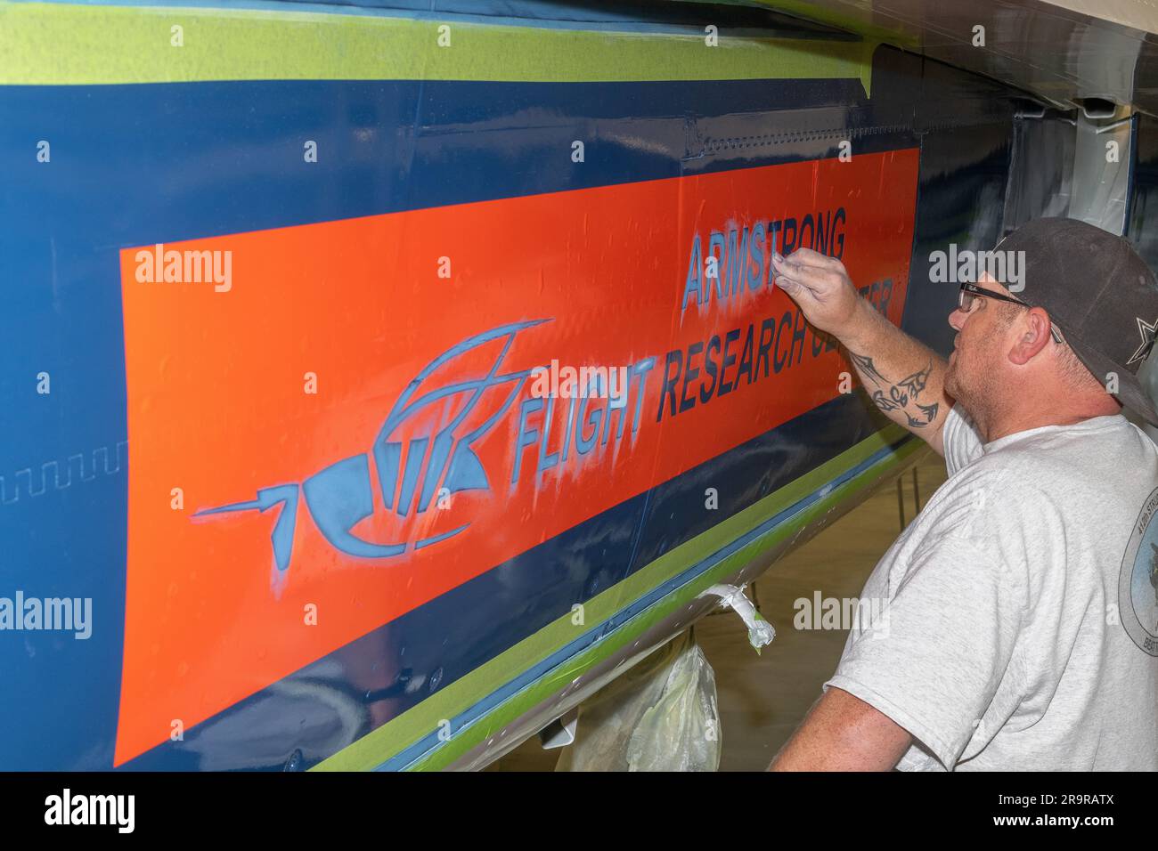 John Bishop della U.S. Air Force Corrosion Control Facility sabbiò aree stencil per i ritocchi finali sulla NASA 862, un F/A-18D con sede presso l'Armstrong Flight Research Center di Edwards, California, nel Paint Barn della Edwards Air Force base. Foto Stock