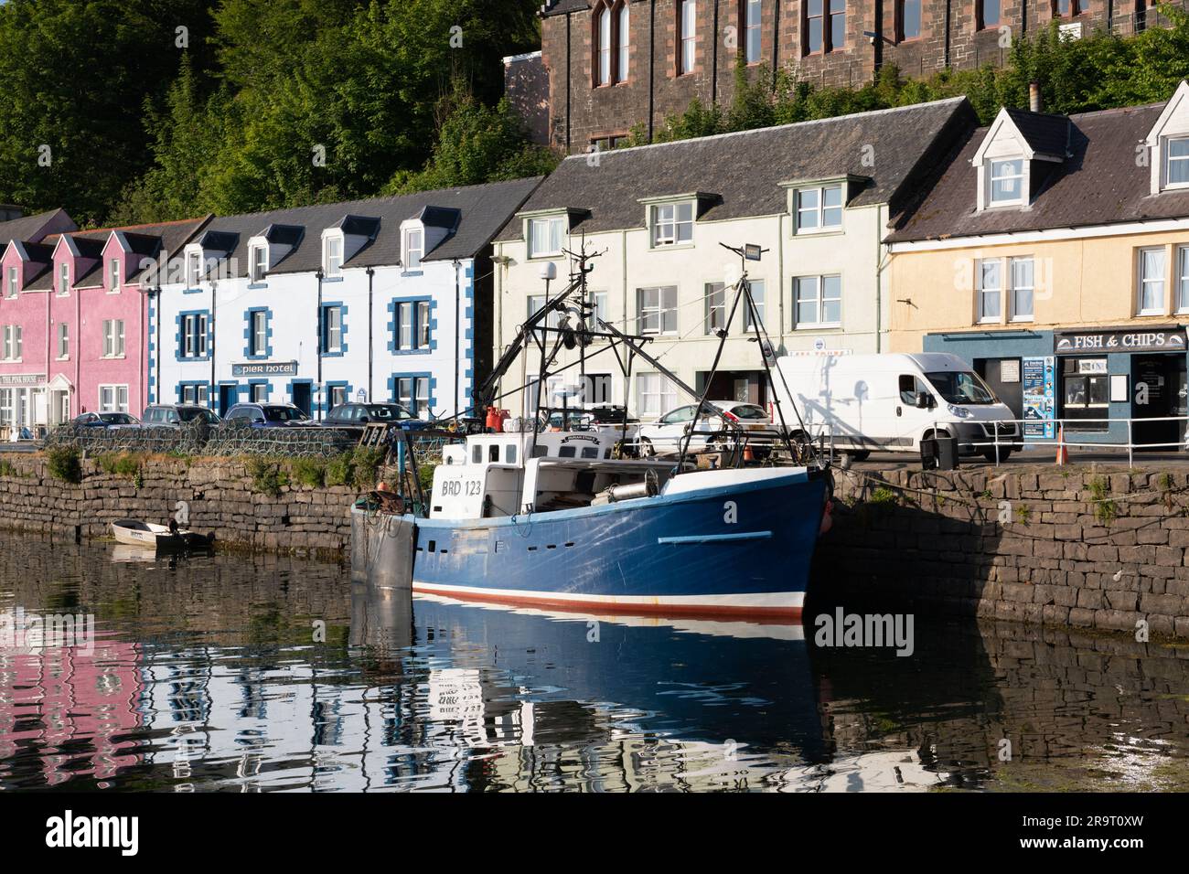Un peschereccio (Dunan Star II) ormeggiato al Quayside nel porto di Portree, Isola di Skye, di fronte agli edifici dai colori vivaci di Quay Street. Foto Stock