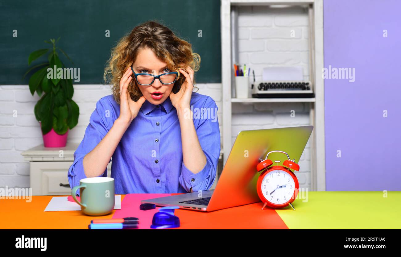 Lavoro da insegnante. Insegnante donna con portatile in classe. Apprendimento e istruzione. Insegnante professionista o professore universitario seduto al tavolo con Foto Stock