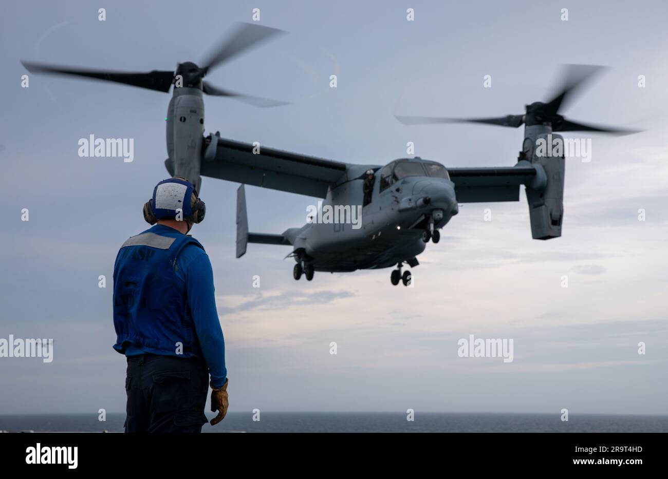 230623-N-XO158-1105 OCEANO ATLANTICO (23 giugno 2023) l'Airman Aaron Schwarzman osserva come MV-22B Osprey, assegnato ai "Blue Knights" del Marine Medium Tiltrotor Squadron (VMM) 365, atterra sul ponte di volo della nave d'assalto anfibio USS Wasp (LHD 1) durante le operazioni di volo, 23 giugno 2023. WASP è in corso di esecuzione di test e valutazioni della fase di base. (STATI UNITI Foto della Marina di Mass Communication Specialist 2nd Class Sydney Milligan) Foto Stock