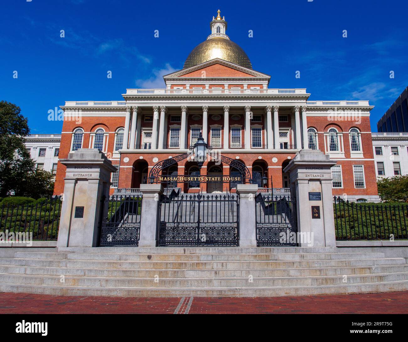 La cupola dorata o cupola del Campidoglio, con le sue pareti di mattoni rossi, si staglia contro il cielo blu nel cuore di Boston. Foto Stock