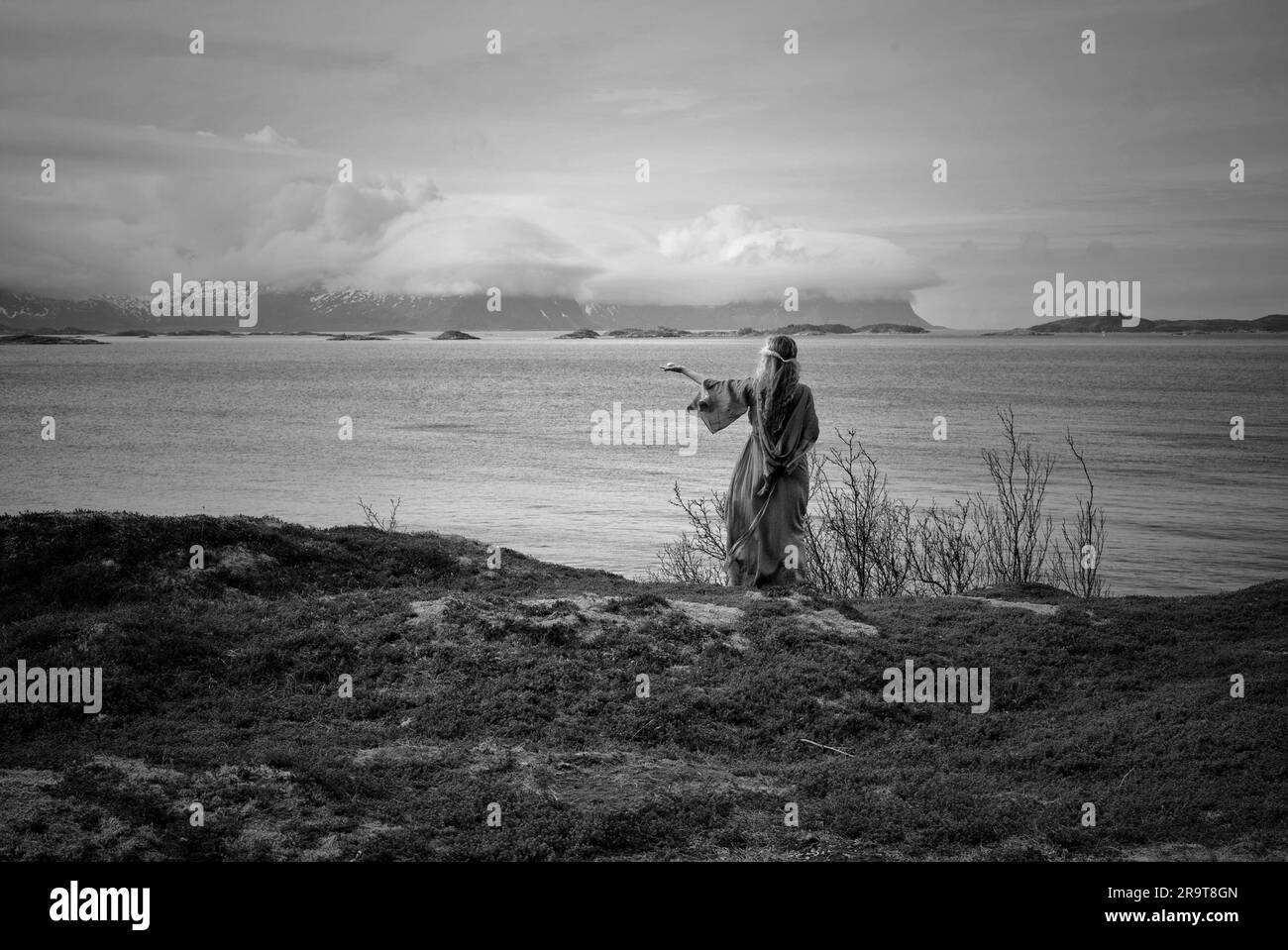 Donna pagana norrena che fa un'offerta al mare. Foto Stock