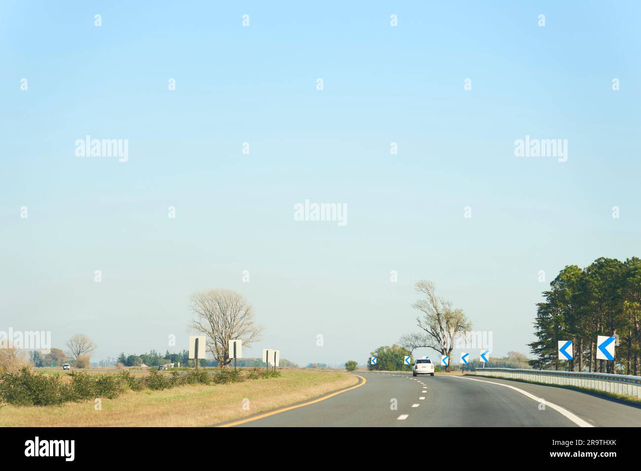 Concetto: Viaggiare su strada, un'auto che guida lungo una strada in una giornata di sole. Foto Stock