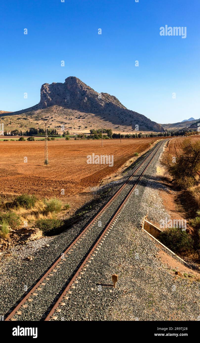 Binari ferroviari che conducono verso la montagna pena de los Enamorados (roccia degli amanti) alta 880 metri, provincia di Malaga, Andalusia, Spagna Foto Stock