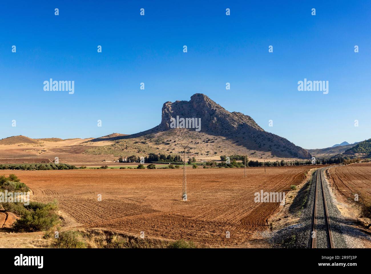 Binari ferroviari che conducono verso la montagna pena de los Enamorados (roccia degli amanti) alta 880 metri, provincia di Malaga, Andalusia, Spagna Foto Stock