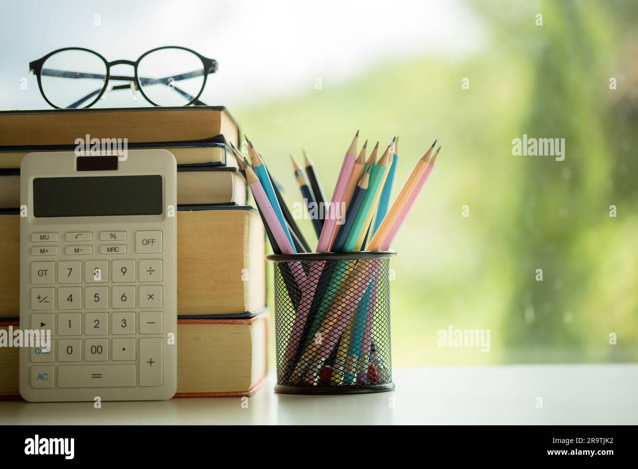 Educazione agli oggetti sfondo naturale verde con pila di libri antichi o vecchia bibbia, libro di carta aperta su un tavolo di legno con spazio per le copie. concetto di ritorno a. Foto Stock