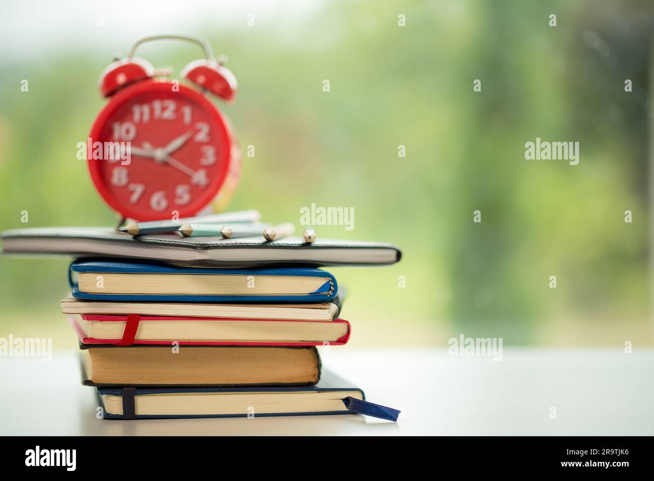 Educazione agli oggetti sfondo naturale verde con pila di libri antichi o vecchia bibbia, libro di carta aperta su un tavolo di legno con spazio per le copie. concetto di ritorno a. Foto Stock