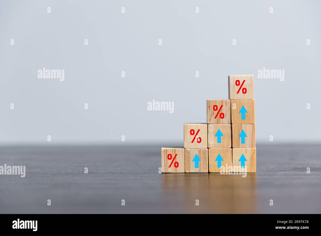 Closeup cubetti di legno con simbolo percentuale, percentuale e frecce crescenti verso l'alto su cubetti di legno. Aumento o prezzo dei tassi ipotecari di interesse finanziario Foto Stock