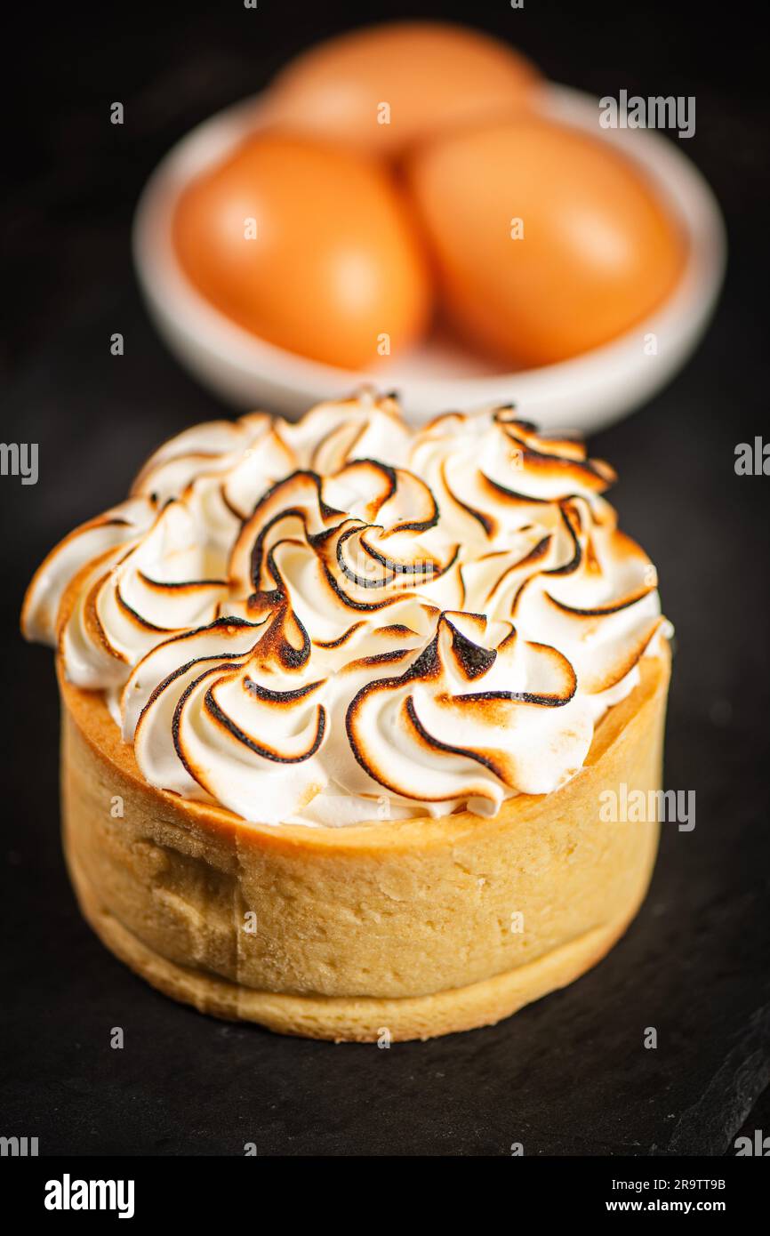 Torta di meringa al limone fatta con pasta sfoglia, cagliata al limone e meringa italiana bruciata. Foto Stock