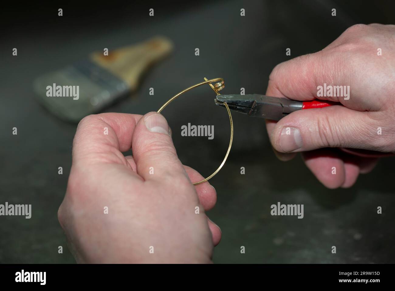 Maestro di gioielleria al lavoro nella fabbricazione di un anello d'oro. Fabbrica di gioielli. Foto Stock