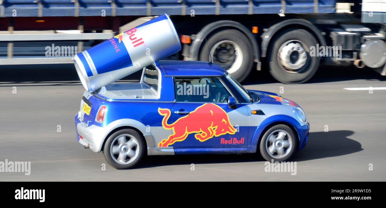 Pubblicità personalizzata Red Bull marchio energia bevanda incorporando grande lattina & logo in mini auto carrozzeria guida su autostrada M25 strada Essex Inghilterra UK Foto Stock