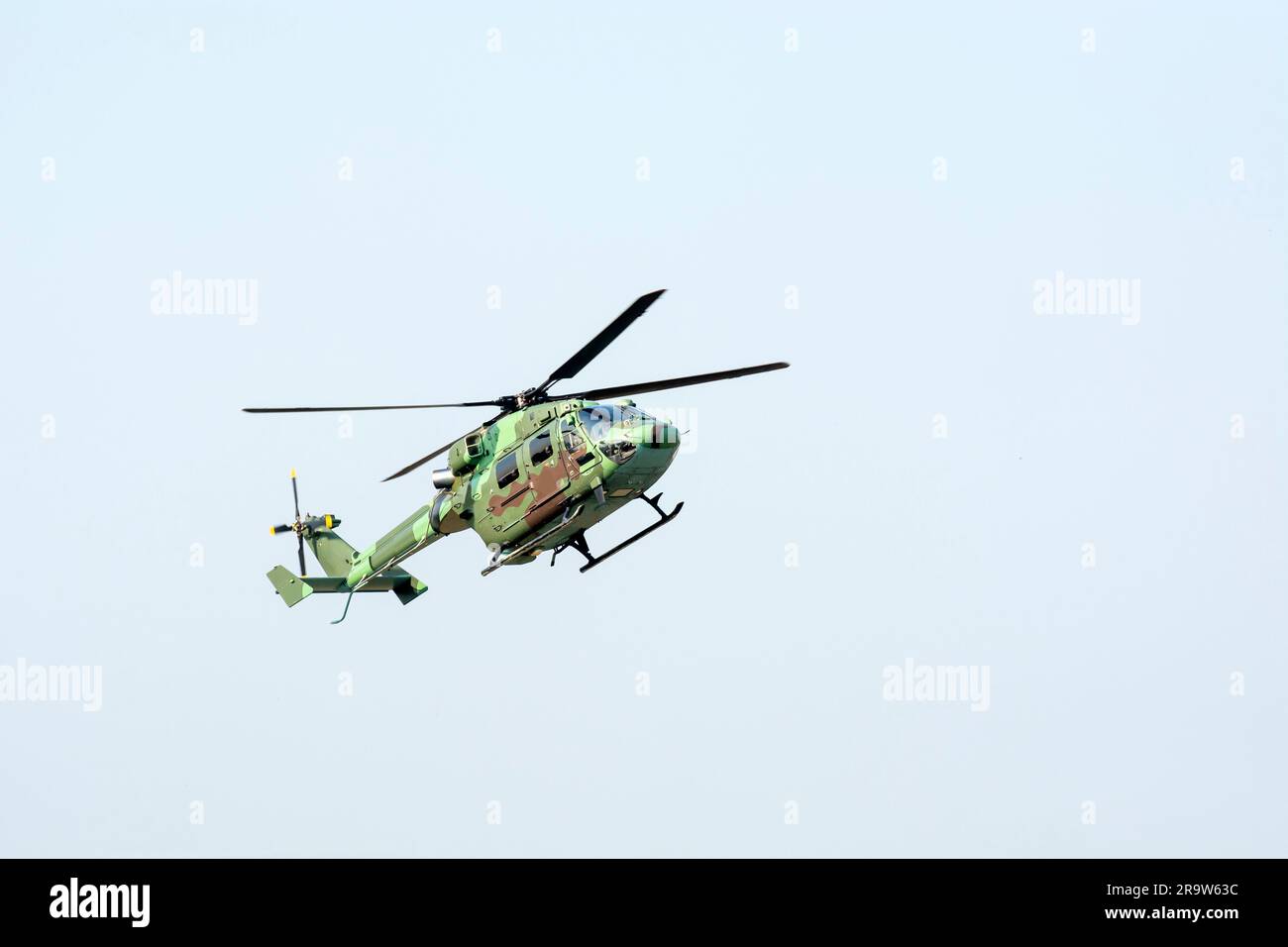 Primo piano dell'elicottero da combattimento sta volando contro un cielo blu isolato. Foto Stock