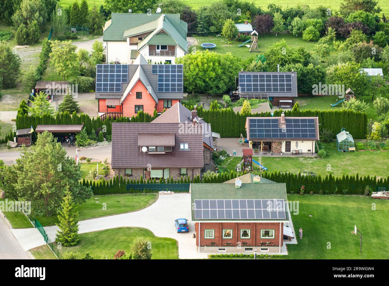 Vista aerea dei pannelli solari sul tetto delle case a schiera in campagna. Centrale solare. Pannelli solari blu. Fonte alternativa di energia elettrica Foto Stock
