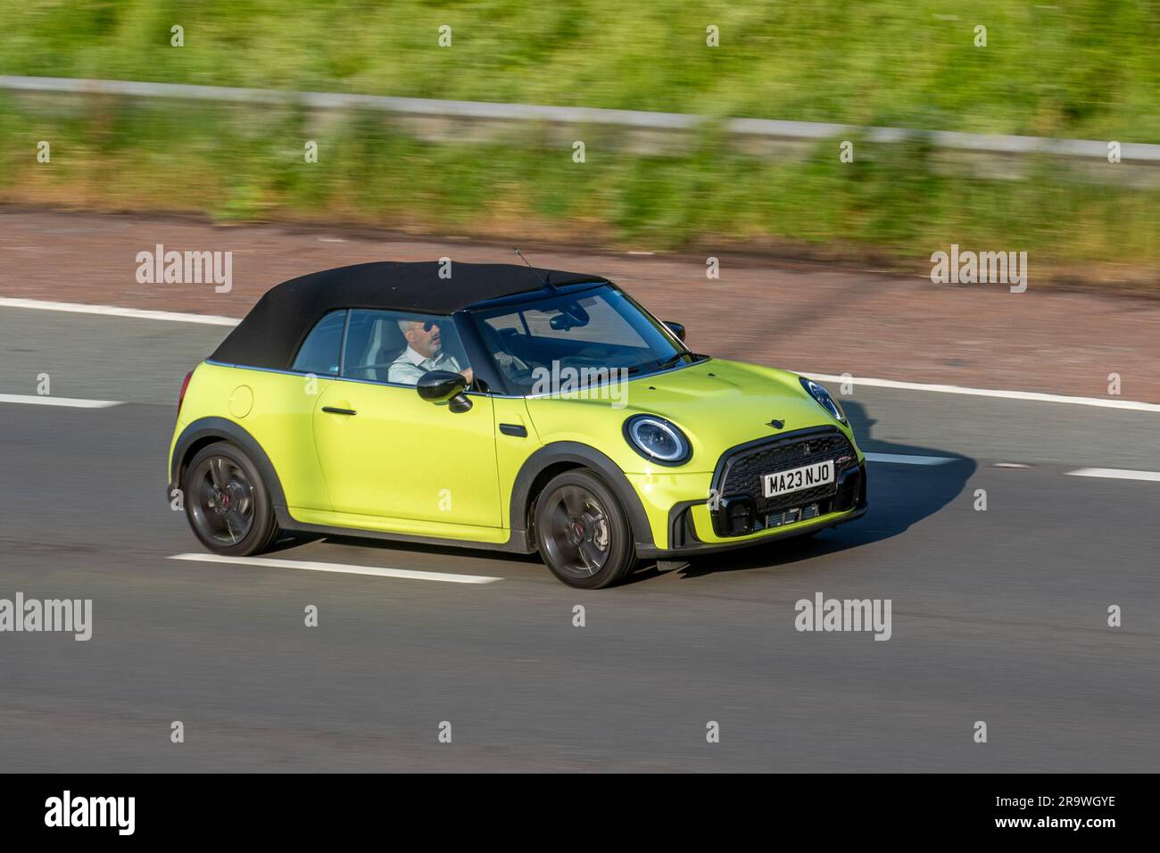 2023 Yellow Mini Cooper Sport Auto 136 Steptronic Auto Start/Stop Car Cabriolet benzina 1499 cc; viaggia a velocità sostenuta sull'autostrada M6 a Greater Manchester, Regno Unito Foto Stock