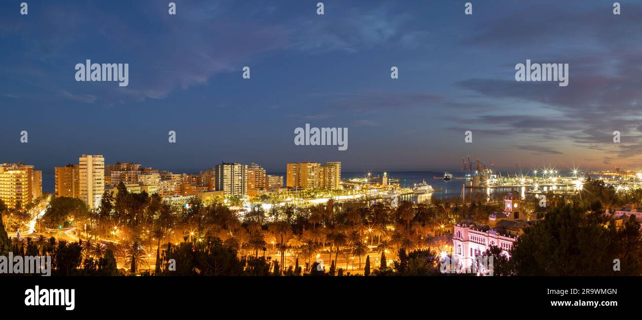 Una vista panoramica sul quartiere di la Malagueta durante l'ora Blu con il quartiere Muelle uno a Malaga, Spagna Foto Stock