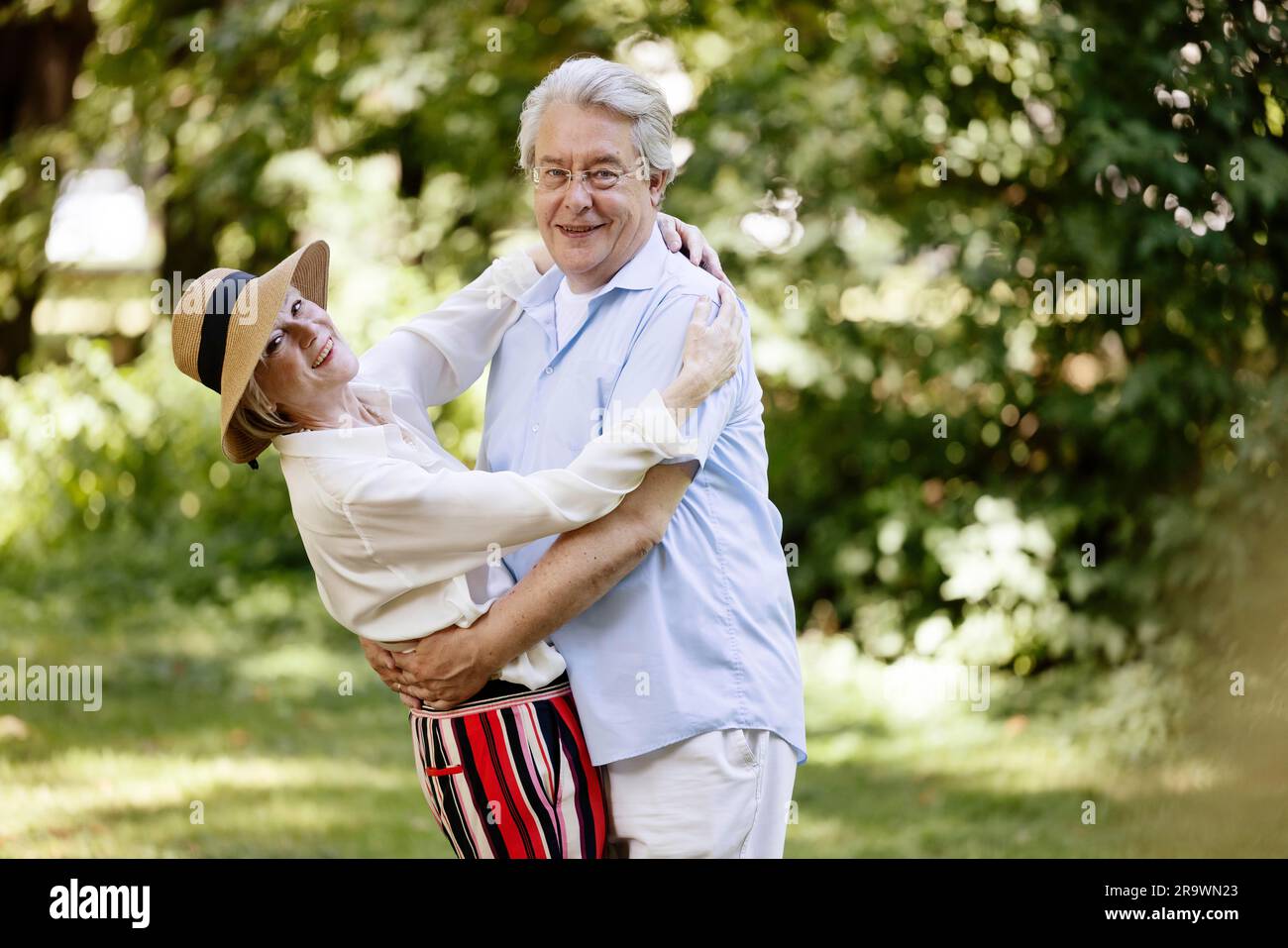 Germania, coppia anziana vestita per l'estate, abbracciata e divertita nella natura Foto Stock