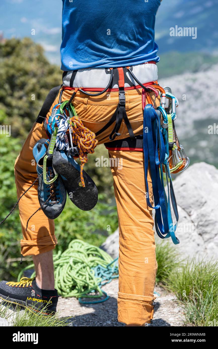 Alpinista con pantaloni da arrampicata, imbracatura, attrezzatura e scarponi da arrampicata, da dietro, arrampicata su più piazze, arrampicata su via la bellezza della Venere, Sarca Foto Stock