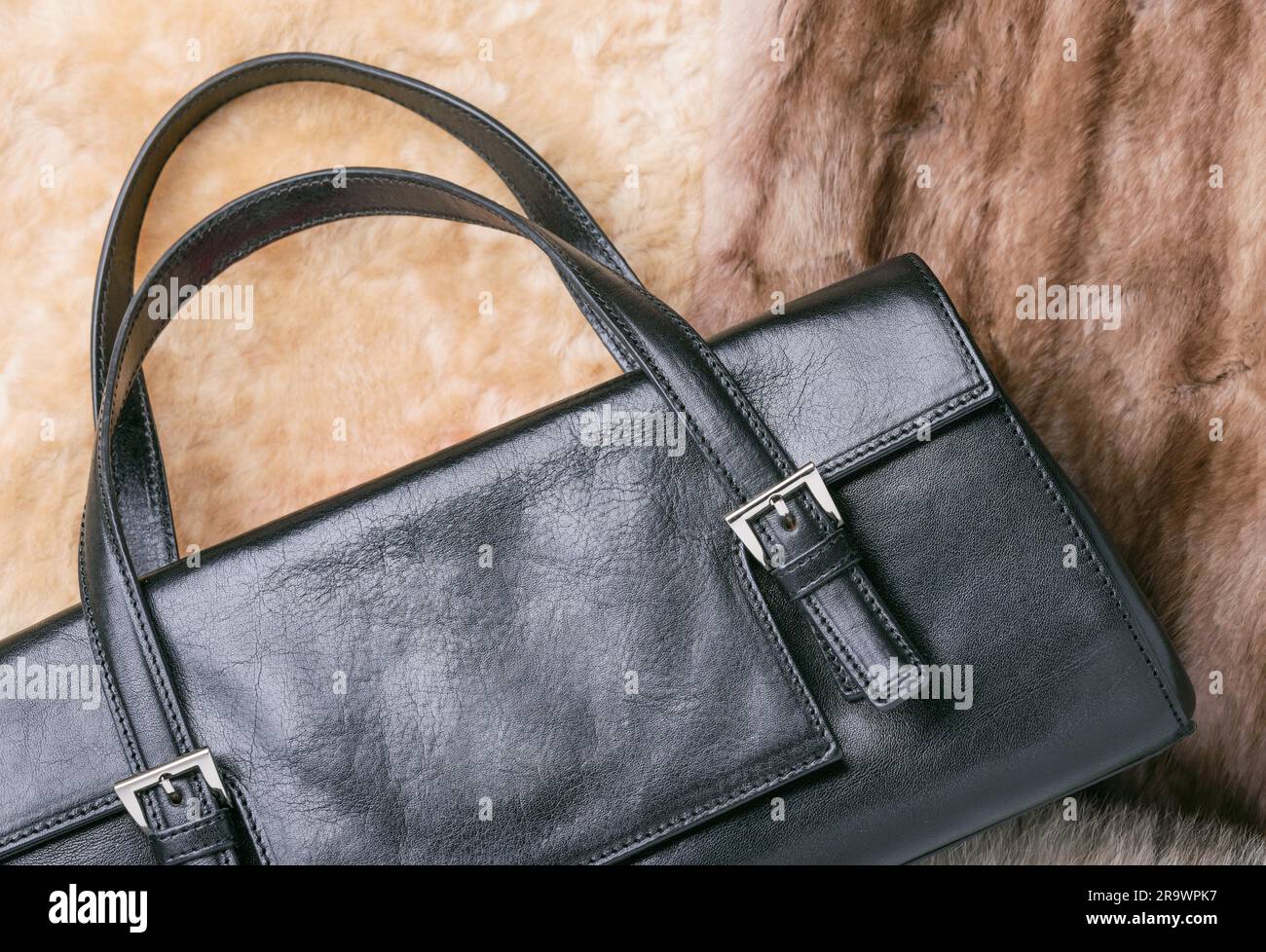 Una borsa in pelle nera con calda pelle di pecora bionda, volpe blu e pellicce di visone rosso zibellino Foto Stock