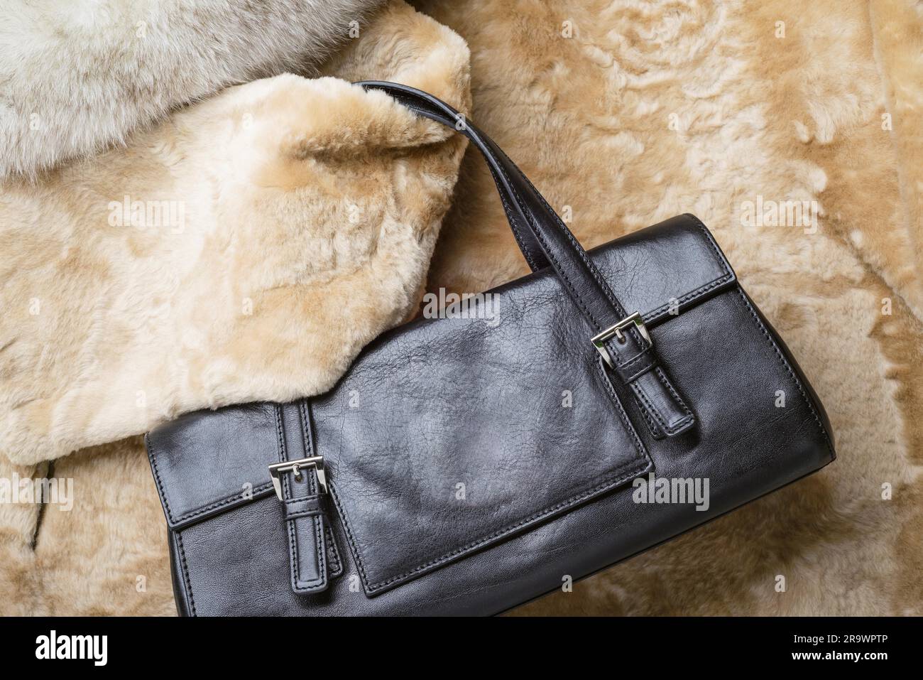 Una borsa in pelle nera con calda pelle di pecora bionda, volpe blu e pellicce di visone rosso zibellino Foto Stock