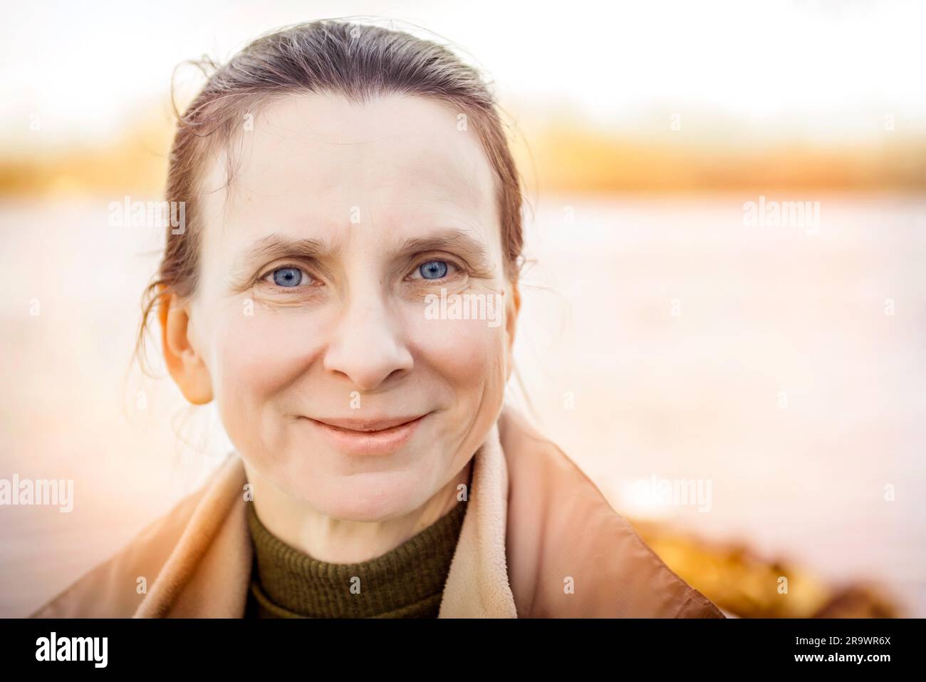 Un caldo ritratto di una bella donna senior vicino al fiume Foto Stock