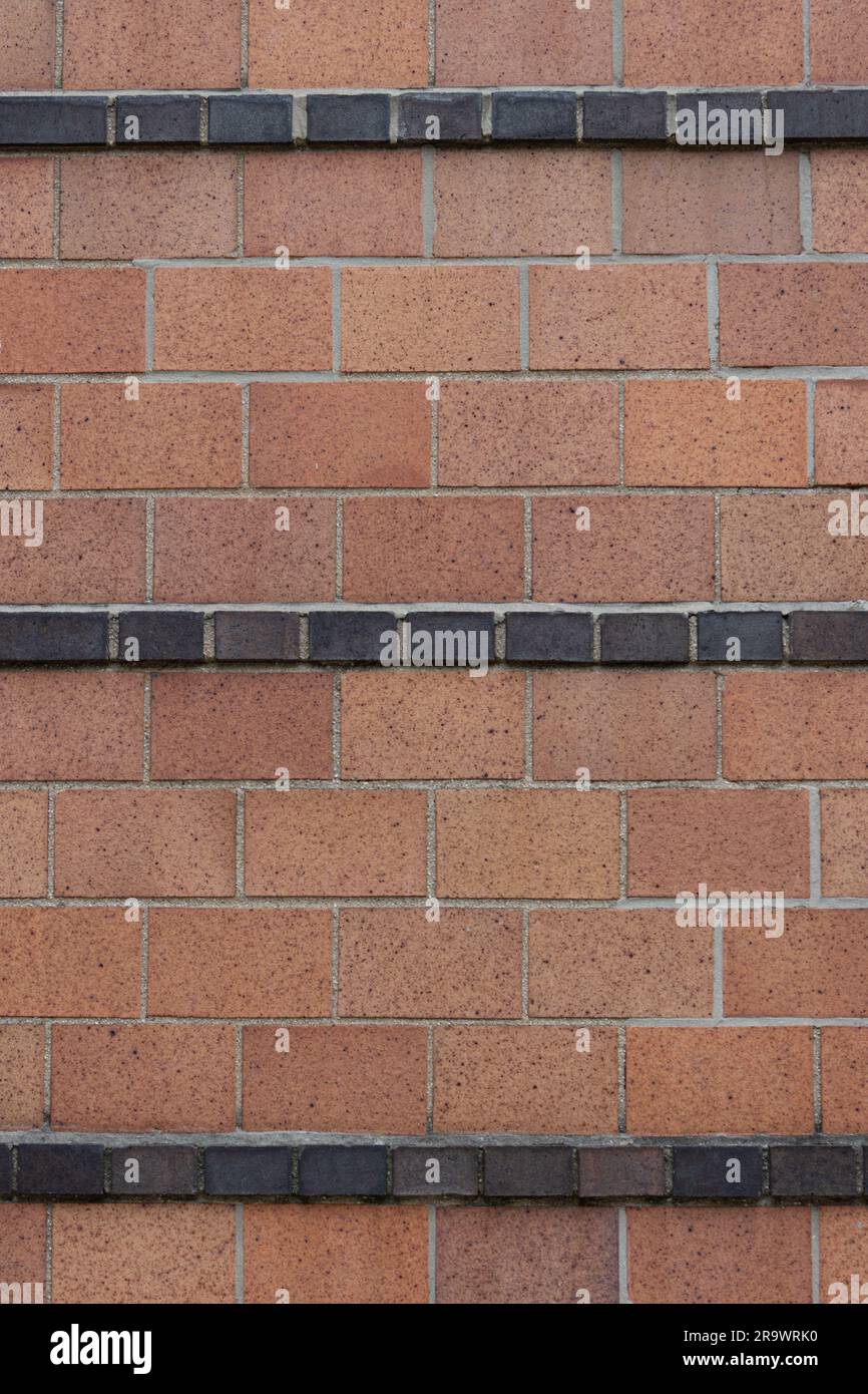 i mattoni in terracotta in barella o con motivo running bond con strisce di mezzo mattone nero creano un mattone decorativo artigianale in stile art deco Foto Stock