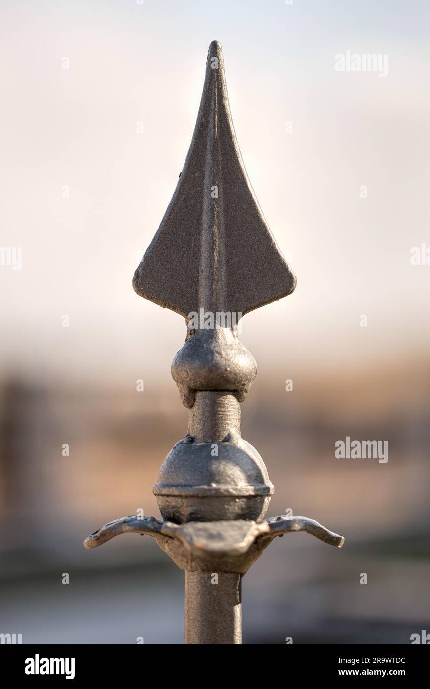 Primo piano dettaglio di una freccia metallico su una recinzione Foto Stock