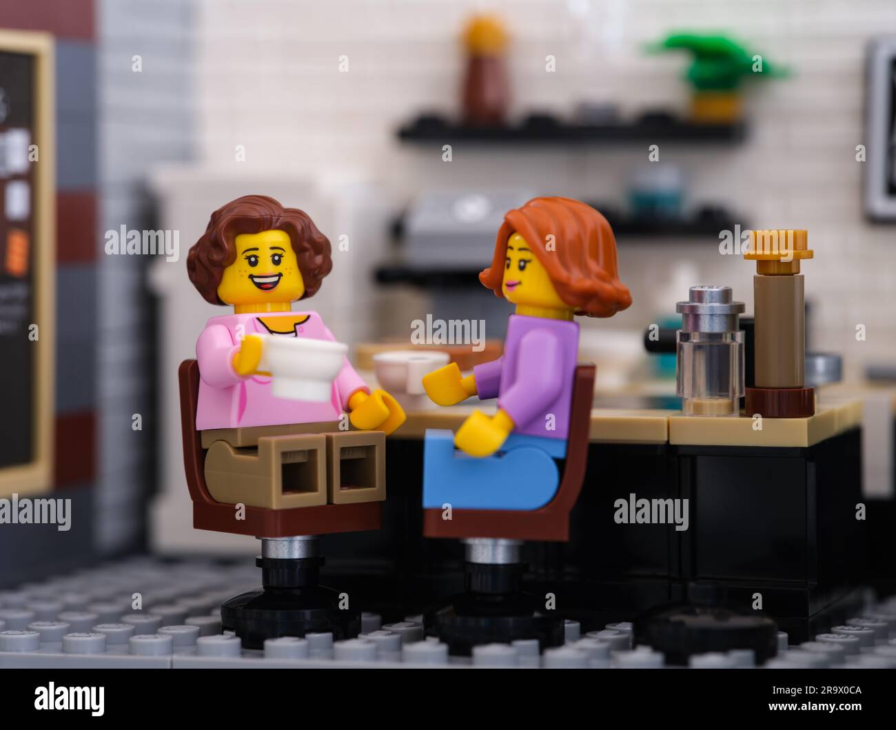 Tambov, Federazione Russa - 22 giugno 2023 due minifigure di donna Lego sedute dietro un tavolo a bere caffè Foto Stock