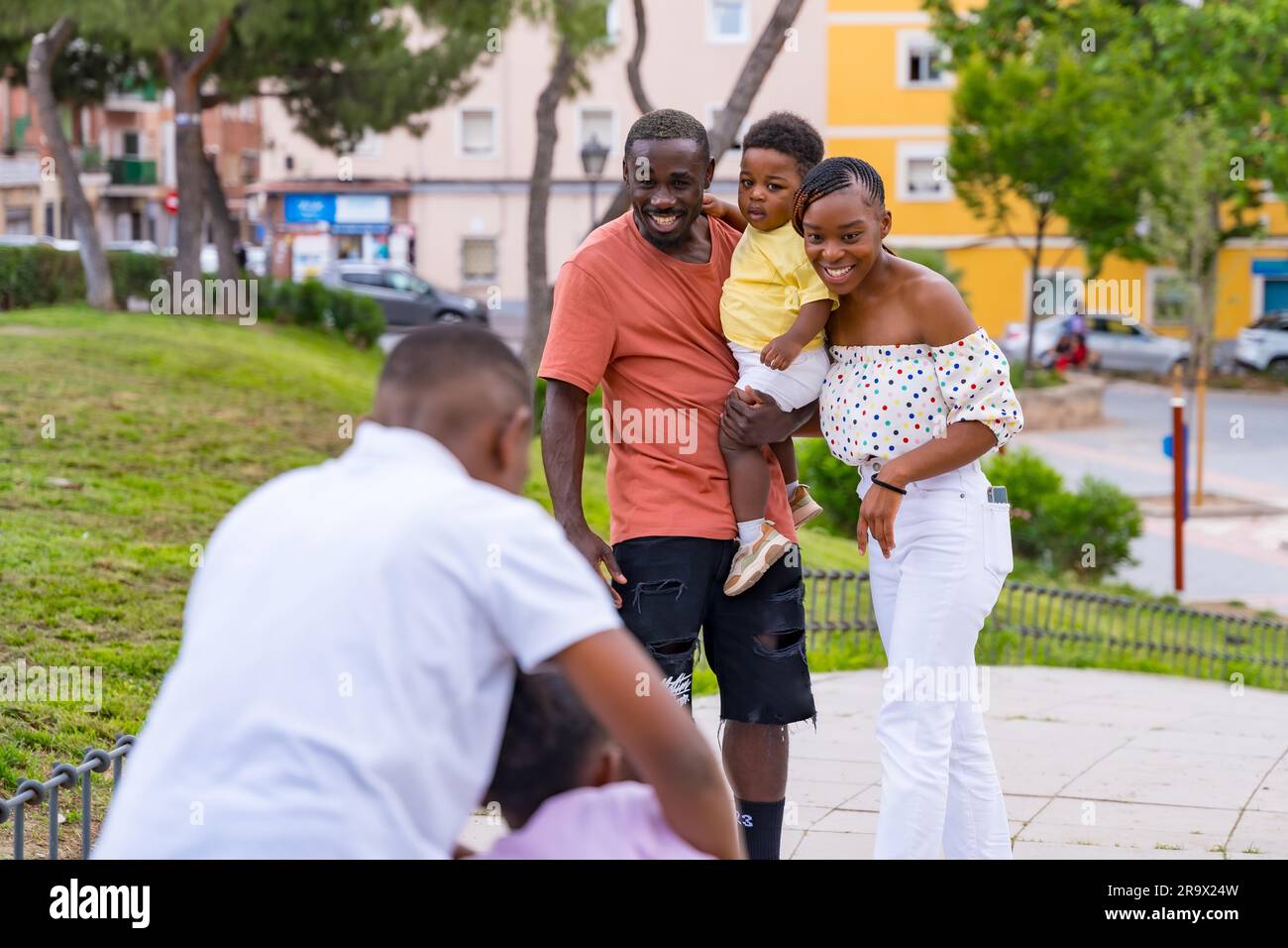 Famiglia di etnia nera africana che si diverte con i bambini felici insieme nel parco cittadino Foto Stock