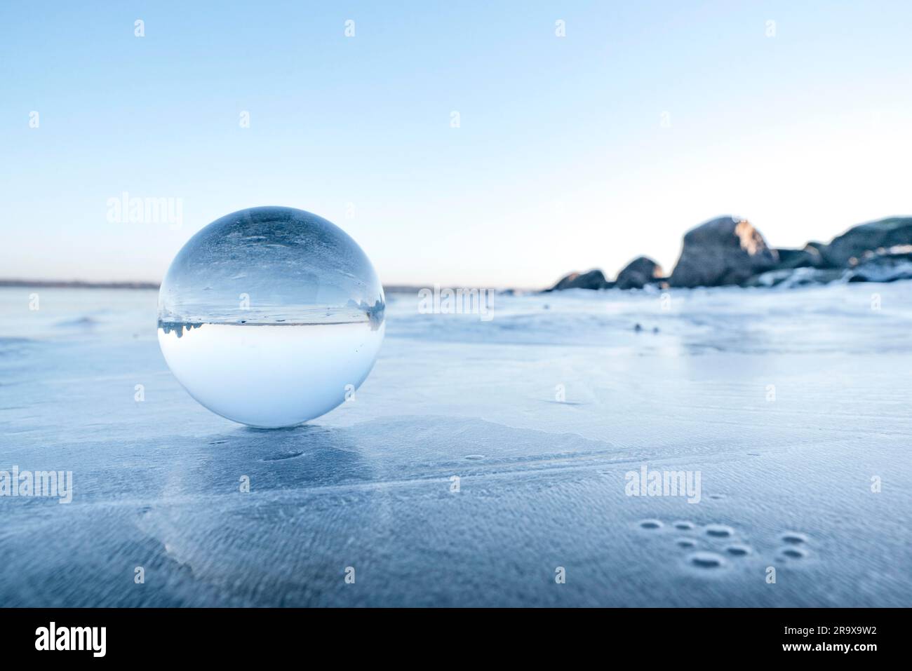 Sfera di vetro su un lago ghiacciato in inverno su una bella mattina in inverno Foto Stock
