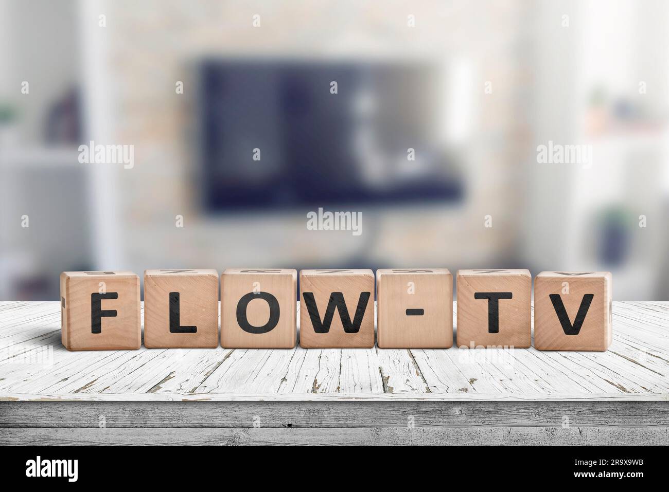 Flow-tv segno su una tavola di legno in un salotto con una tv a parete Foto Stock