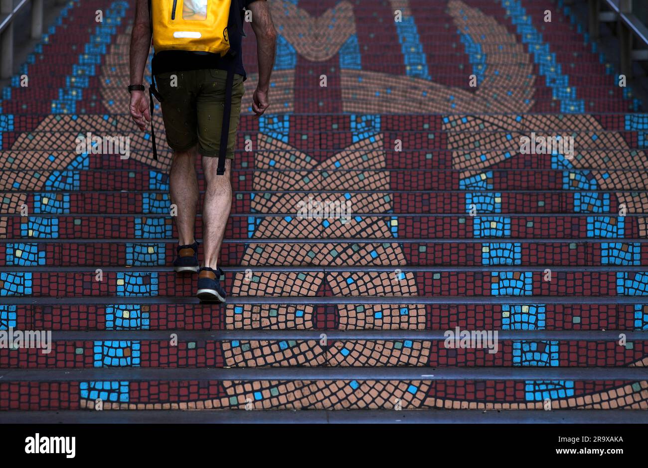 Uomo con zaino, giallo, scalate, scale, mosaico, Stoccarda, Baden-Wuerttemberg, Germania Foto Stock