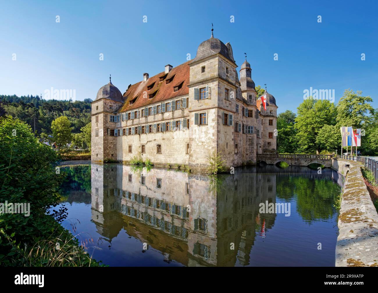 Castello con fossato di Mitwitz, vista nord-est con ponte in pietra e fossato, edificio rinascimentale a tre piani a quattro ali con tetti a spiovente, torri angolari e. Foto Stock