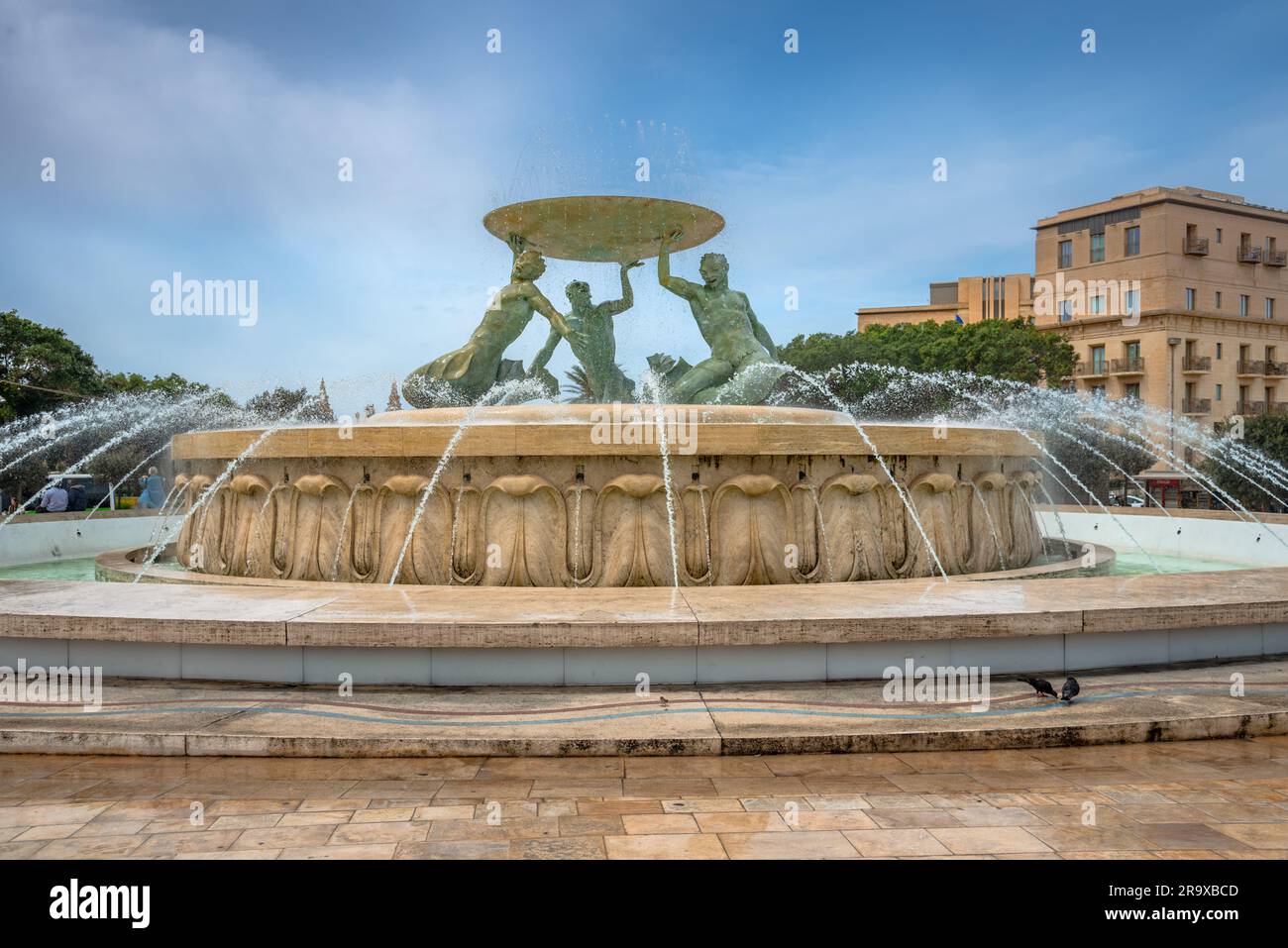 Iconica fontana Tritone di fronte alla porta della città di la Valletta, capitale di Malta Foto Stock