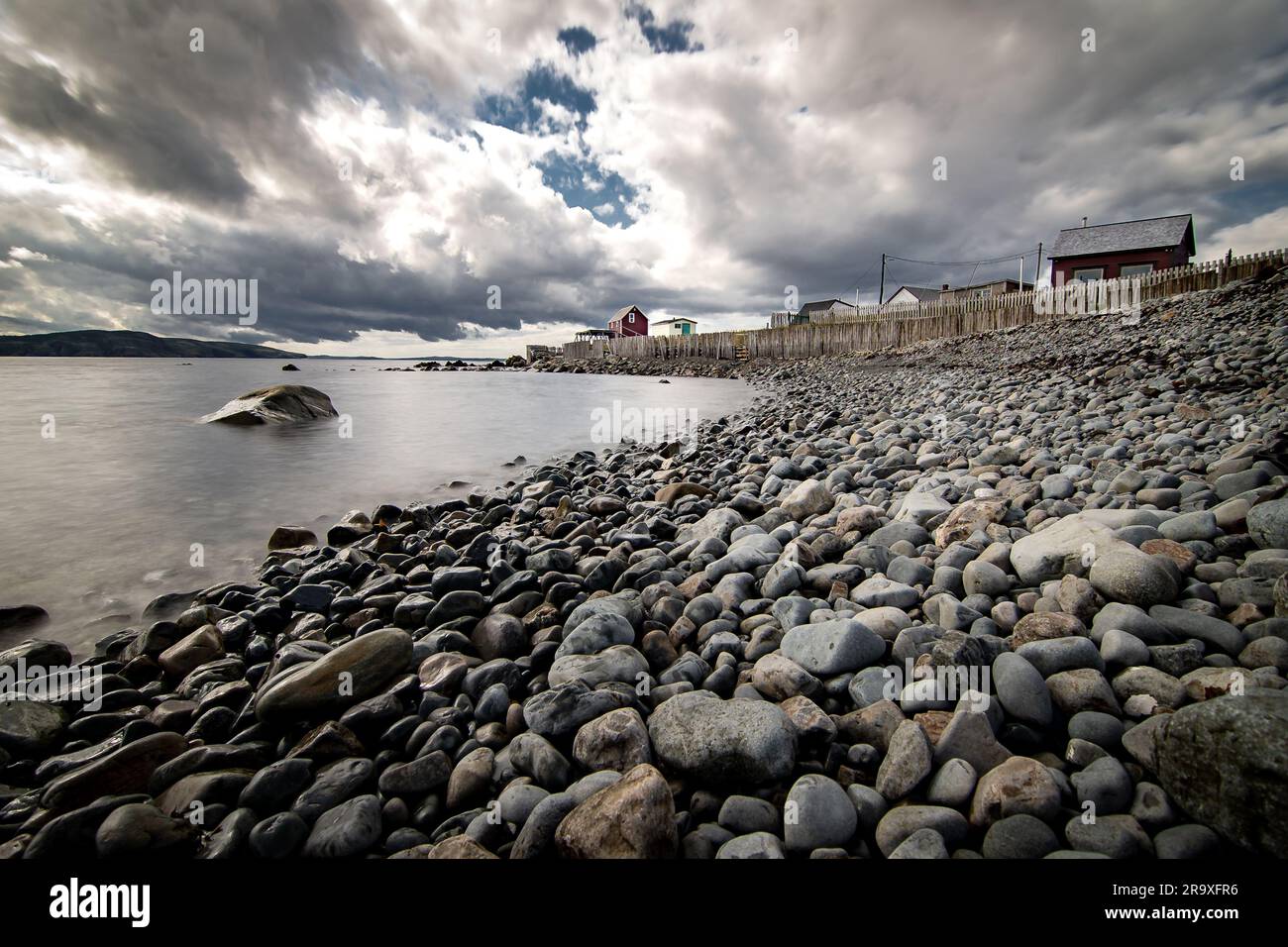 Lungo litorale roccioso che si affaccia sulla rustica casa delle barche con la griglia di essiccazione del merluzzo Atlantico a Bonavista, Terranova, Canada. Foto Stock