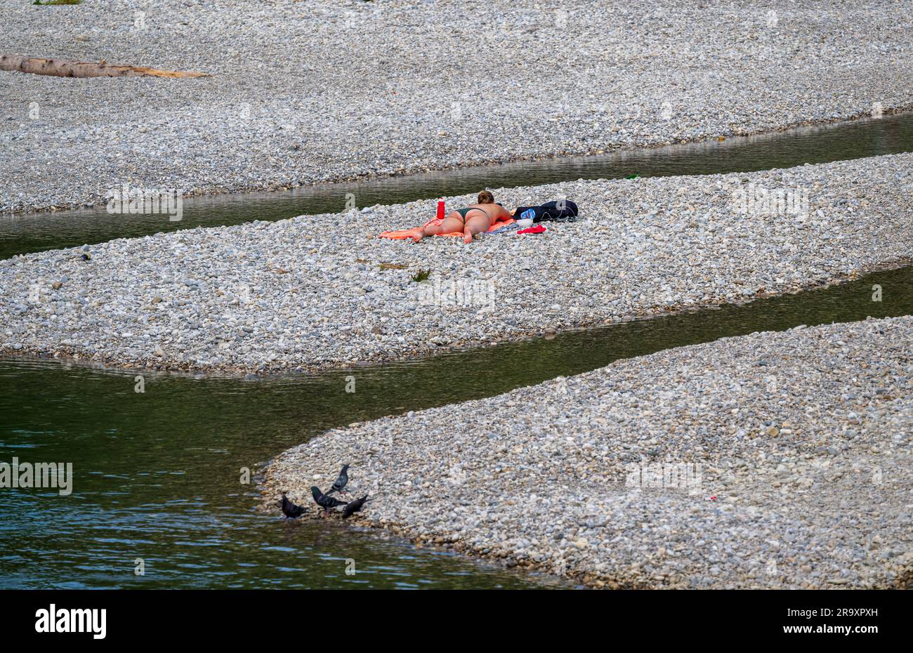 Monaco, Germania. 29 giugno 2023. Una donna gode del clima caldo sulle rive ghiaiose del fiume Isar, che un tempo scorre attraverso la capitale bavarese. Crediti: Peter Kneffel/dpa/Alamy Live News Foto Stock