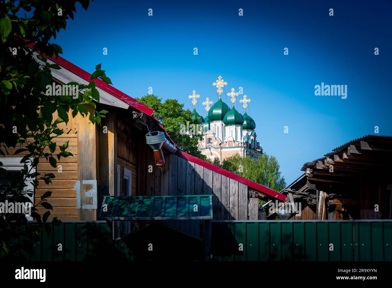 Case di legno nella città di Solvychegodsk, Federazione russa. Monastero ortodosso della presentazione di Maria nel Tempio sullo sfondo Foto Stock