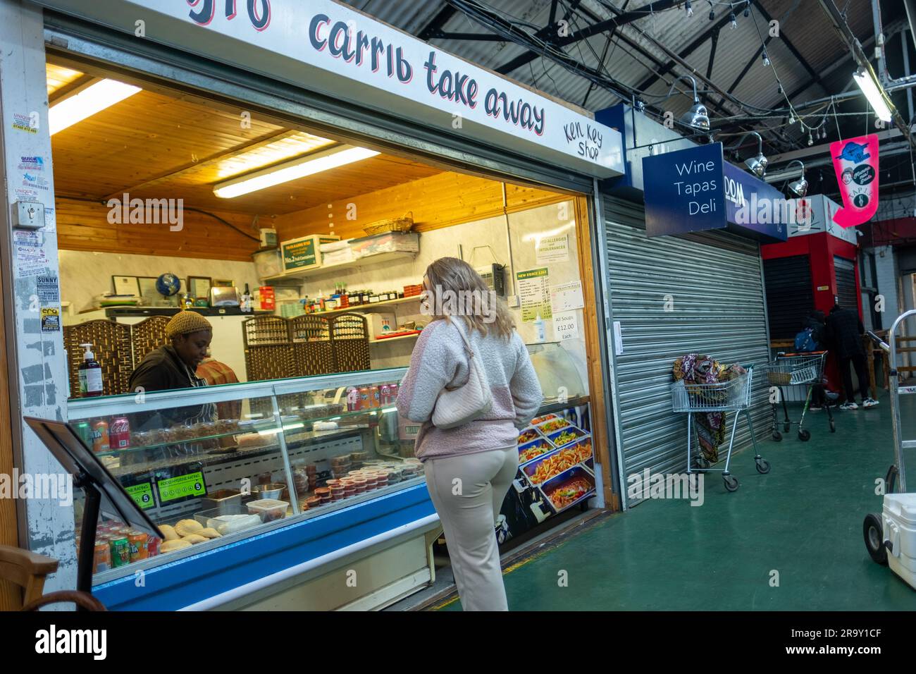 LONDRA - APRILE 2023: Tooting Market nel sud-ovest di Londra, un mercato al coperto con molti venditori di cibo di strada e commercianti Foto Stock