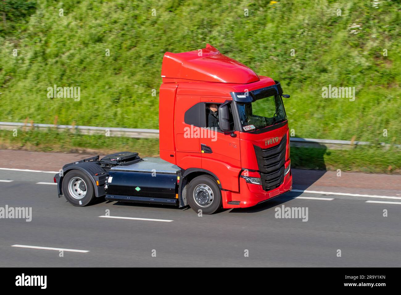 Nuovo camion a gas per impieghi gravosi Red IVECO S-WAY 460. Trattore standard per autocarri pesanti alimentati a gas naturale; viaggia a velocità sostenuta sull'autostrada M6 a Greater Manchester, Regno Unito Foto Stock